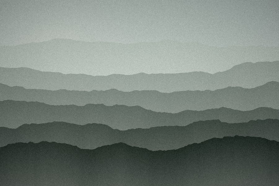 Receding green-grey ridges dissolving into valley fog
